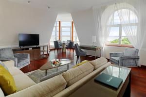 a living room with a couch and a table with chairs at Sheraton Sopot Hotel in Sopot