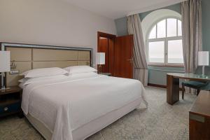 a bedroom with a large white bed and a window at Sheraton Sopot Hotel in Sopot