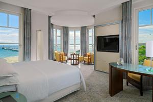 a bedroom with a bed and a desk and a television at Sheraton Sopot Hotel in Sopot