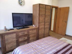 a bedroom with a television on a wooden dresser at Vila Kuća mira in Konjic