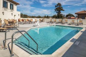 a swimming pool with chairs and tables and chairs at Courtyard by Marriott Santa Cruz in Santa Cruz
