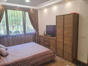 a bedroom with a bed and a dresser with a television at Vila Kuća mira in Konjic