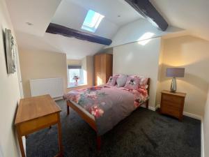 a bedroom with a bed and a table and a window at Mountain Dream Ramsey Isle of Man in Ramsey