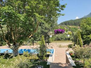a garden with a swimming pool and a flower pot at Vila Kuća mira in Konjic