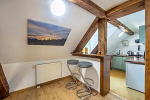 uma cozinha com dois bancos num quarto com vigas de madeira em Gipfelstürmer em Nesselwang