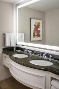 a bathroom with two sinks and a large mirror at Gaylord Palms Resort & Convention Center in Orlando