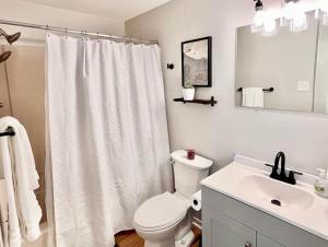 uma casa de banho com uma cortina de chuveiro branca e um lavatório. em Golf, Bike, Lake Cottage 3 BR 5 min Bryce Resort em Basye