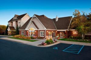 a large house with a driveway in front of it at Residence Inn Minneapolis St. Paul/Roseville in Roseville