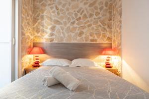 a bedroom with a large bed with two lamps at Hotel De Belgique à Menton in Menton