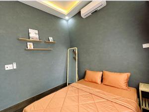een slaapkamer met een bed met een oranje kussen bij Mario Home in Phu Quoc