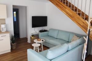 a living room with a blue couch and a tv at LA 4g - Ferienreihenhaus in Schottwarden