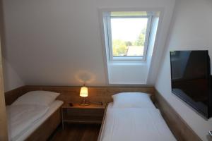 a small room with two beds and a television at LA 4g - Ferienreihenhaus in Schottwarden