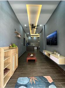 een woonkamer met een bank en een tv aan de muur bij Mario Home in Phu Quoc