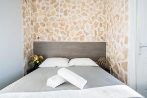 a bedroom with a bed with two pillows on it at Hotel De Belgique à Menton in Menton