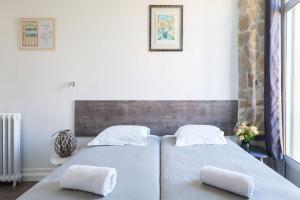 two beds in a bedroom with two pillows at Hotel De Belgique à Menton in Menton