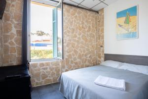 a bedroom with a bed and a window with a view at Hotel De Belgique à Menton in Menton
