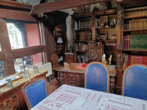 een eetkamer met een tafel en stoelen en boekenplanken bij maison Alsacienne du 18eme siècles in Brumath