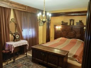 een slaapkamer met een groot houten bed en een tafel bij maison Alsacienne du 18eme siècles in Brumath