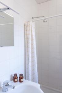 a bathroom with a sink and a shower curtain at Hotel De Belgique à Menton in Menton