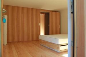 Habitación vacía con cama y armarios de madera. en Maiensäss La Scera Val Poschiavo, 