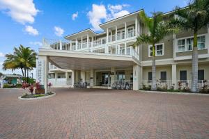 a large white building with palm trees in front of it at Waterline Villas & Marina, Autograph Collection in Holmes Beach