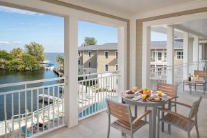 a balcony with a table and chairs and a view of the water at Waterline Villas & Marina, Autograph Collection in Holmes Beach