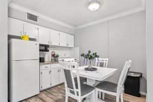 uma cozinha com uma mesa e cadeiras e um frigorífico branco em Sunset Beach Suites em St. Pete Beach
