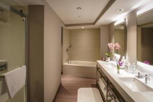 a bathroom with two sinks and a bath tub at San Juan Marriott Resort and Stellaris Casino in San Juan