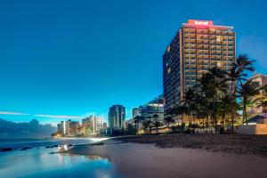 vista su una spiaggia con un edificio alto di San Juan Marriott Resort and Stellaris Casino a San Juan