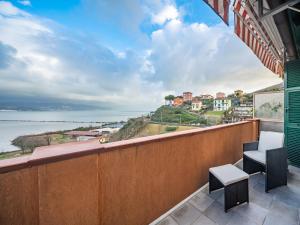 a balcony with two chairs and a view of the water at LA SCALA MATTA - Seaview Penthouse in La Spezia