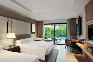 pokój hotelowy z 2 łóżkami i basenem w obiekcie Hua Hin Marriott Resort and Spa w mieście Hua Hin