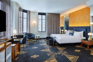 a hotel room with a bed and a desk at W Minneapolis - The Foshay in Minneapolis