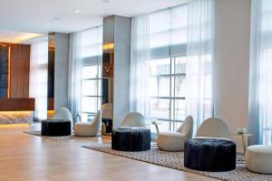 a lobby with white and black chairs and windows at AC Hotel by Marriott Portland Downtown, OR in Portland