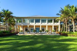 una casa grande con palmeras delante en St. Regis Bahia Beach Resort, Puerto Rico, en Río Grande