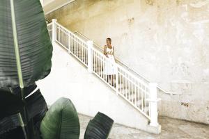 Una mujer con un vestido blanco bajando las escaleras en St. Regis Bahia Beach Resort, Puerto Rico, en Río Grande