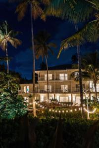 a hotel at night with palm trees and lights at St. Regis Bahia Beach Resort, Puerto Rico in Rio Grande
