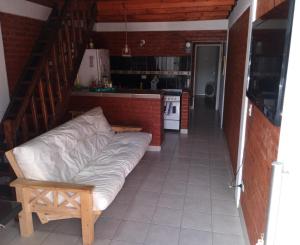 a couch sitting in a room with a kitchen at Departamentos Ensueños in Trelew