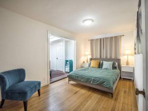 a bedroom with a bed and a chair and a window at Relaxing 3 bedroom Santa Cruz house, 5min to beach in Santa Cruz