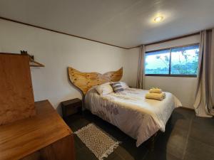 sypialnia z łóżkiem i oknem w obiekcie Cabañas Kainga w mieście Hanga Roa