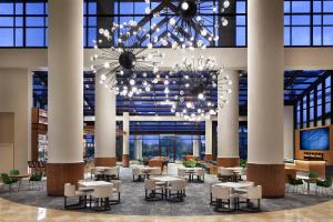 a lobby with tables and chairs and a chandelier at Orlando World Center Marriott in Orlando