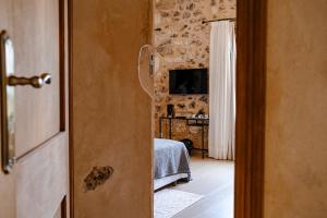 a door to a bedroom with a bed in a room at Finca Gomera - Agroturismo Hotel in Cala Pi