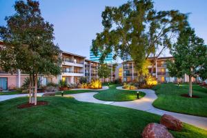 um complexo de apartamentos com um pátio com árvores e relva em Santa Clara Marriott em Santa Clara