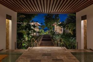 una scala che conduce a una casa con palme di Dorado Beach, a Ritz-Carlton Reserve a Dorado