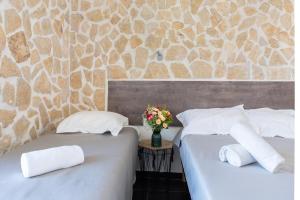 two beds with white pillows and a vase of flowers at Hotel De Belgique à Menton in Menton