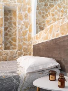 a bedroom with a bed and a stone wall at Hotel De Belgique à Menton in Menton