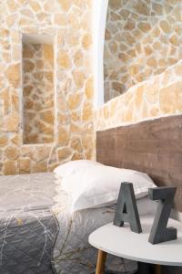 a bed with a table and a stone wall at Hotel De Belgique à Menton in Menton