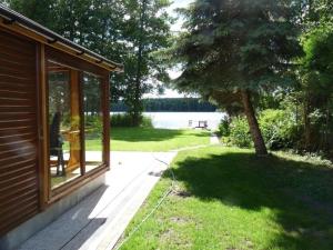 desde el porche de una casa con vistas al lago en Ferienhaus mit eigenem Strand, en Barnówko