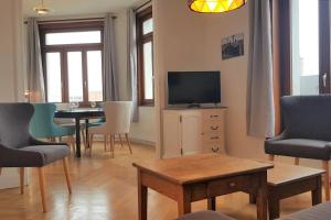 a living room with a tv and a table and chairs at Little Suite - Amelie in Marcq-en-Baroeul