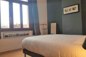 a bedroom with a large bed and two windows at Little Suite - Amelie in Marcq-en-Baroeul