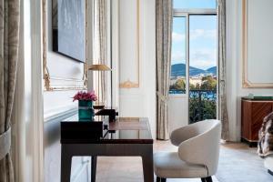 Zimmer mit einem Schreibtisch, einem Stuhl und einem Fenster in der Unterkunft The Ritz-Carlton Hotel de la Paix, Geneva in Genf